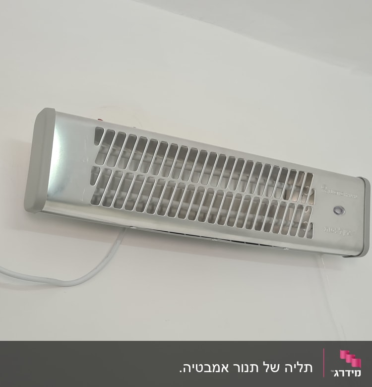 תנור חימום מותקן על קיר עם חיבור לחשמל